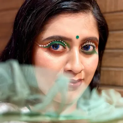 For this Independence Day theme, I created a bold eye look using green liner and strategically placed crystals to form an artistic wing. Paired with a simple bindi, this look is a modern tribute.