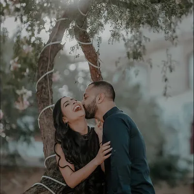 The perfect candid shot. The groom's kiss on her cheek elicits a burst of genuine laughter from the bride, capturing a moment of pure, unscripted happiness.