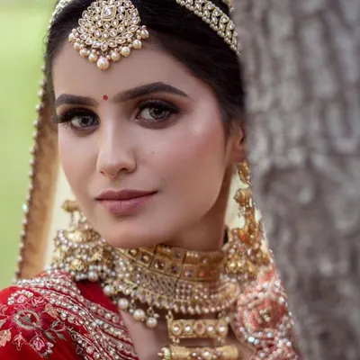 A detailed close-up of a complete bridal jewellery set available for rent. This set includes a statement matha patti and a heavy choker, perfect for a traditional bridal look.