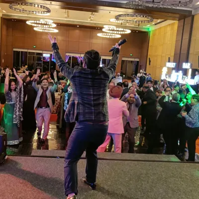 This is my favorite view, from the stage looking out at a dance floor full of happy people. As your anchor, I make it my mission to ensure every single guest feels like part of the celebration.