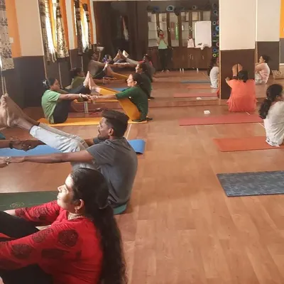 The studio filled with energy during a partner yoga class. Here, students are practicing Navasana (Boat Pose) together, using each other for support and balance. It’s a playful way to build core strength and trust.