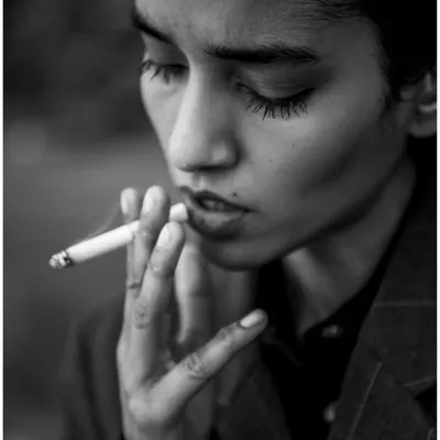 An intimate black and white close-up that feels like a still from a classic film. The lighting is soft and moody, focusing on the model's expression.