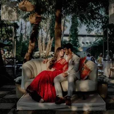 Capturing a quiet moment amidst the celebration. We designed this cozy seating area for the happy couple against a backdrop of lush greenery and bohemian decor, perfect for timeless engagement photos.
