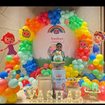 A vibrant Cocomelon themed birthday party for a 3-year-old. This colorful setup features a rainbow balloon arch, character cutouts of JJ and friends, and a personalized backdrop.