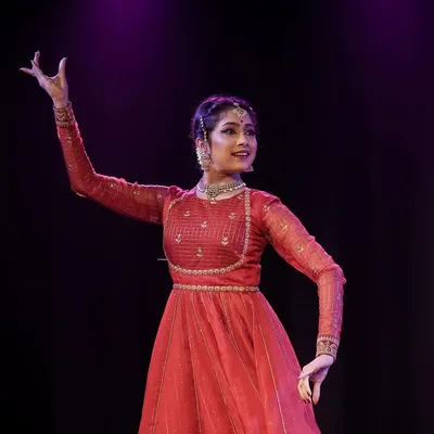 A solo moment on stage during a Kathak performance. This portrait captures the elegance of the costume and the expressive hand gestures, or mudras, used in storytelling.