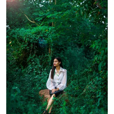 An on-location fashion shoot set in lush greenery. Even outside the studio, we use natural light and composition to create stunning, atmospheric portraits.