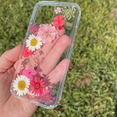 This custom floral phone case is made with a vibrant mix of real, pressed daisies and other pink and red flowers. Each flower is carefully placed to create a beautiful, one-of-a-kind botanical design.