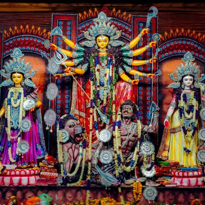 A full view of the Durga Puja pandal at Chittaranjan Park, New Delhi. This shot captures the main idol of Maa Durga along with other deities, showcasing the complete, grand tableau of the celebration.