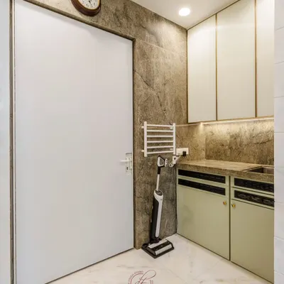 This utility area is designed for maximum efficiency. It features a dedicated sink, a wall-mounted drying rack, and seamless cabinetry, all set against a durable, textured wall finish.