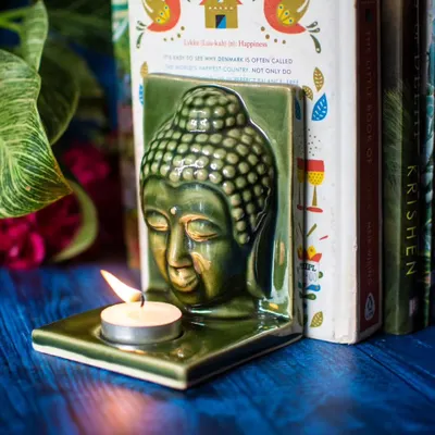 We love creating pieces that are both beautiful and versatile. This serene, green ceramic Buddha head is designed not just as a tealight holder, but also as a unique bookend to bring a sense of peace to your bookshelf. It also includes a hole in the back for wall hanging.