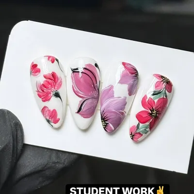 This is the level of detail and artistry my students achieve. This example of student work shows intricate, hand-painted floral designs on almond-shaped nail tips, demonstrating the high-quality techniques taught in my nail art design workshops.