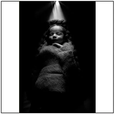 This is an example of my artistic newborn photography. Using dramatic lighting and a soft wrap, I create powerful, fine art portraits that highlight the serene beauty of your sleeping baby.