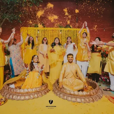 Celebrating each other with every prayer the haldi contains. A beautiful shot of the couple and their family showering them with flower petals.