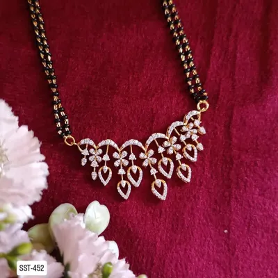 A modern take on the traditional mangalsutra, this piece is crafted from 92.5 silver with gold plating. It features a beautiful floral pendant made of American diamonds for a touch of sparkle.