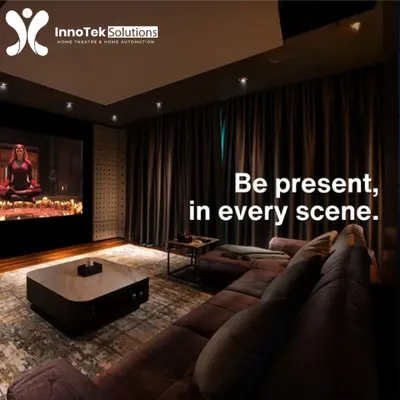 This living room doubles as a high-end cinema with blackout curtains, a large L-shaped sofa for ample seating, and a professionally calibrated sound system.