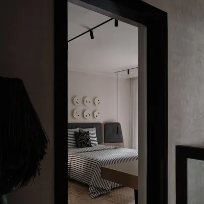A glimpse into a bedroom at The Grove Residence, where we used a monochromatic palette and playful wall art to create a youthful yet sophisticated space. The view through the doorway creates a sense of depth and discovery.