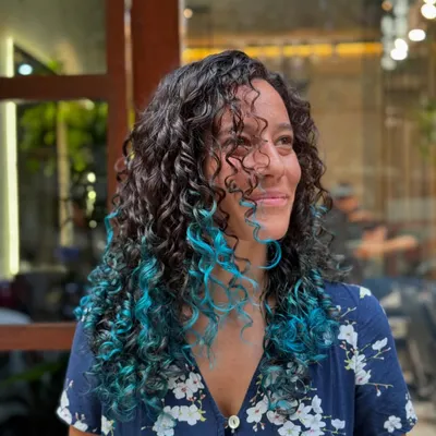 A peekaboo of bright turquoise adds an element of surprise and fun to these dark curls.