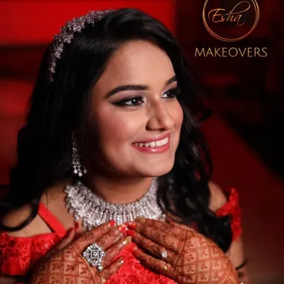 A stunning bride ready for her reception in a sparkling red gown. The makeup is pure glamour, with soft smokey eyes, radiant skin, and a beautiful diamond hair accessory.