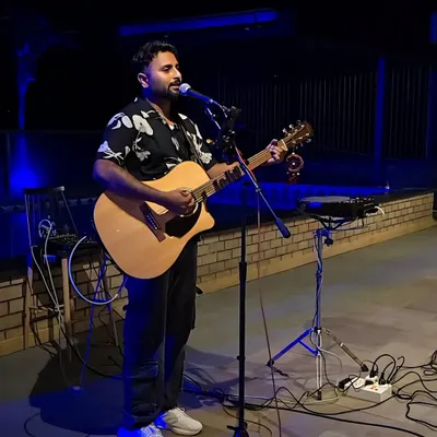 Performing a solo acoustic set at an outdoor venue. The blue uplighting created a cool and relaxed vibe for the evening.