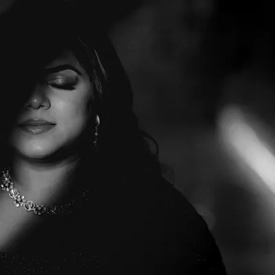 A dramatic black and white portrait of the bride, with light and shadow playing across her face. This artistic shot is full of emotion and mystery.