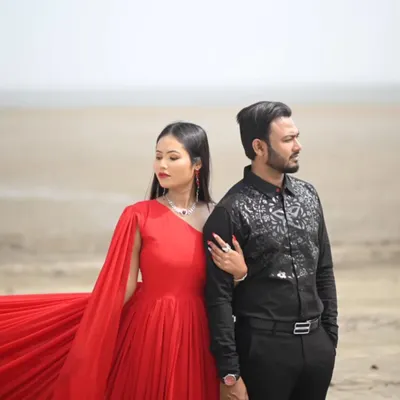 This classic red gown with a single dramatic sleeve is paired perfectly with a black patterned shirt for the groom-to-be. A timeless look for a pre-wedding shoot.