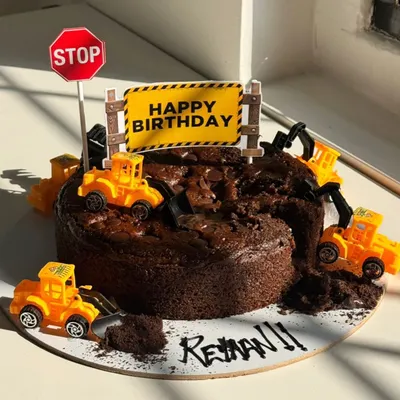 For Rehan's birthday, we created this fun "under construction" themed chocolate cake. Complete with tiny toy bulldozers and a stop sign, it’s a playful design that turns a favorite interest into a delicious celebration.