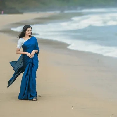 A stunning outdoor photoshoot by the sea. I created a very natural, wind-proof makeup look and a simple, flowing hairstyle to match the elegant blue saree and the beach setting.