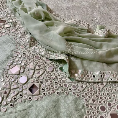 A stunning example of Kutchi hand mirrorwork on our mint green pure raw silk palazzo. The geometric arrangement of mirrors creates a dazzling effect, perfect for festive occasions.