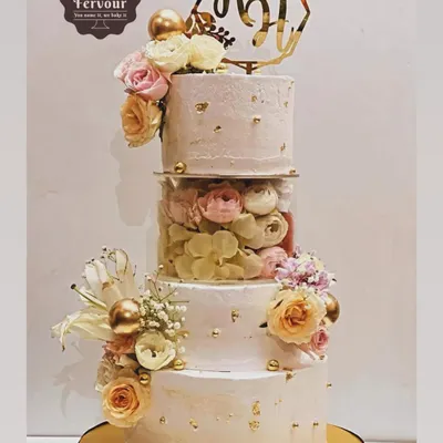 A stunning floral cake perfect for a wedding or grand engagement. This design features three tiers with a transparent separator filled with fresh flowers, combining modern structure with classic romantic style. The flavours were a mix of chocolate mousse and salted caramel.