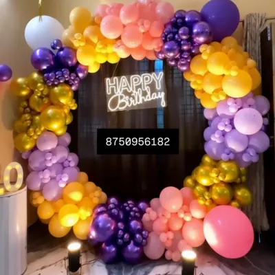 This vibrant circular balloon arch in purple, yellow, and pink makes any birthday pop. Paired with a "Happy Birthday" neon sign and spotlights, it's a fantastic photo corner for your party.