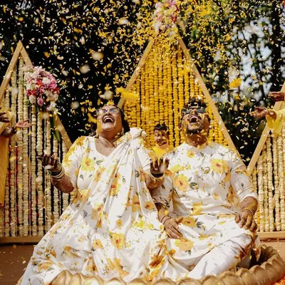 The moment the flower petal shower begins. This is the peak of the Haldi celebration, and capturing the couple's ecstatic reaction is priceless.