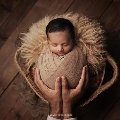 A powerful close-up of a newborn held in their father's hands. This image emphasizes how tiny and precious they are, creating a timeless memory of their first days.