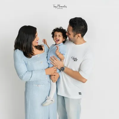 A frame filled with laughter and love. This family portrait captures a genuine moment of joy between parents and their little one.