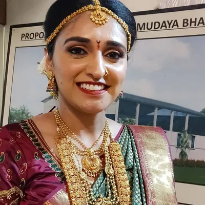 The beautiful Pooja on her big day. For her muhurtham look, we went with a classic red lip, warm gold-toned eyes, and radiant skin to match her traditional gold jewelry and silk saree.