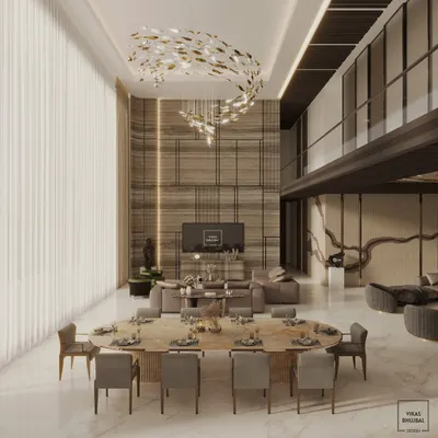 A glimpse into a double-height living and dining area we designed for a luxury penthouse in Mumbai. The space is defined by a dramatic sculptural chandelier, bespoke furnishings, and a mezzanine level, all curated to create an atmosphere of refined elegance.