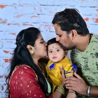 A close-up portrait showing the pure affection of parents for their baby. Dressed in traditional attire, this image highlights the tender moments that make family portraits so meaningful.