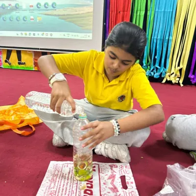 A student from KR Mangalam School carefully prepares her own bottle of bio-enzyme. This hands-on science experiment teaches the principles of fermentation and natural fertilizers.
