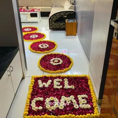 A warm welcome starts at the doorstep. I design beautiful flower rangolis using fresh marigold, rose, and jasmine petals to greet your guests. This 'WELCOME' mat design and the accompanying circular patterns are a popular choice for making any entrance feel special.