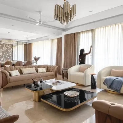 A wide shot of the Anand Niketan project, showcasing the harmonious blend of the living and dining areas under a cohesive, luxurious design scheme.