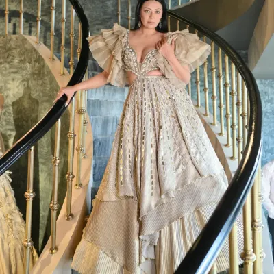 A full-length view of the stunning Kalki Fashion gown. The dramatic ruffled sleeves and intricate mirror work make it a true piece of art. Posing on this spiral staircase highlighted the gown's magnificent structure and flow.