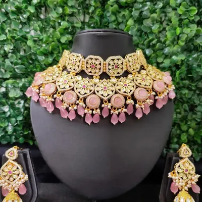 This pastel pink kundan set is a dream for a daytime wedding or a romantic-themed event. The set includes a choker, matching jhumkas, and a maang tikka.