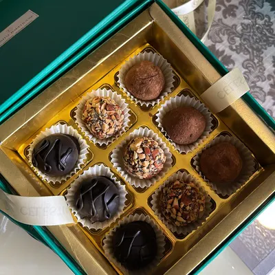 A close-up of our assorted chocolate truffle box. Each truffle is handcrafted with care, featuring flavors like classic dark chocolate, roasted almond, and more.