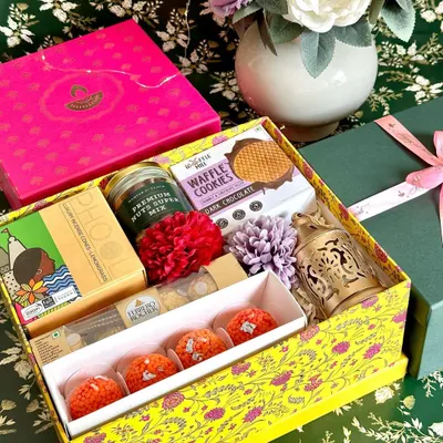 This vibrant yellow Diwali box is a feast for the senses. It's packed with Vahdam tea, Phool incense, waffle cookies, ladoo candles, Ferrero Rocher, a decorative lantern, and a jar of premium nuts, making it a complete festive celebration in a box.