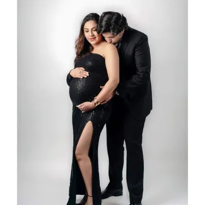 An intimate moment between an expecting couple during their studio maternity shoot. The partner’s gentle kiss on her shoulder speaks volumes of their love and shared anticipation.