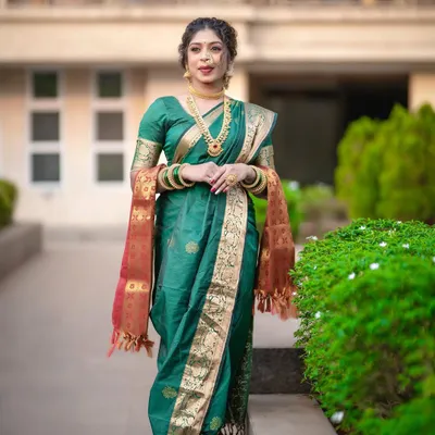 A classic green Nauvari saree, also known as a Kasta saree, is a staple for Maharashtrian brides. This full-length view shows the perfect fall of the drape and the signature pleats at the back.
