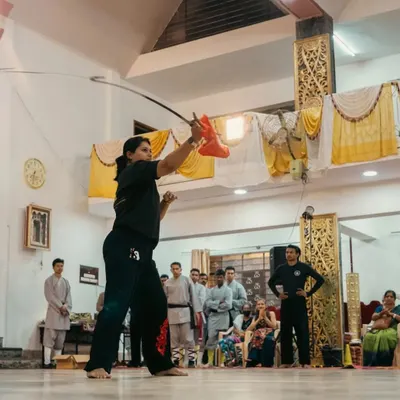 A dynamic action shot of me demonstrating a Wushu sword form. The sword requires precision, fluid movement, and a sharp focus, embodying the spirit of the warrior.
