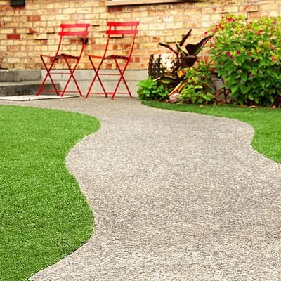 I used artificial grass to create soft, green edges along this winding gravel pathway. This design defines the walkway beautifully and ensures there are no messy edges to trim.