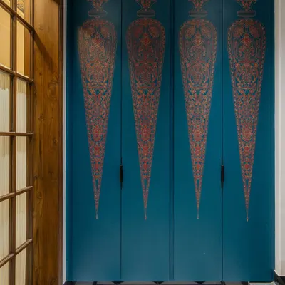 A closer look at the hand-painted shutters of the foyer shoe cabinet. Each motif is inspired by Indian miniature art, meticulously painted by artisans to create a functional piece that doubles as a stunning work of art, setting a tone of bespoke elegance from the moment you enter.