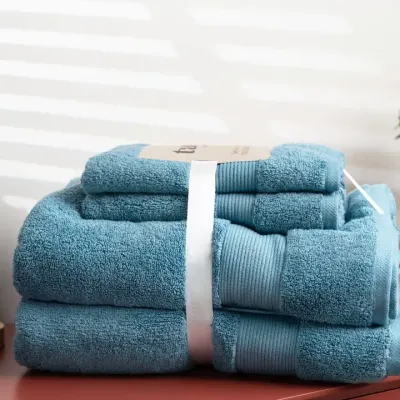 A neatly folded set of blue towels on a modern bathroom counter. We use clean lines and bright lighting to create fresh and appealing images for home essentials.