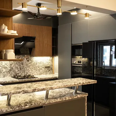 This open-plan kitchen features a multi-level island with a granite countertop that doubles as a breakfast bar. We used a combination of dark grey and wood-finish cabinets, complemented by modern track lighting, to create a sophisticated and inviting culinary space.
